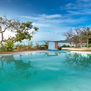 Serene poolside view with ocean backdrop, perfect for relaxation and leisure.